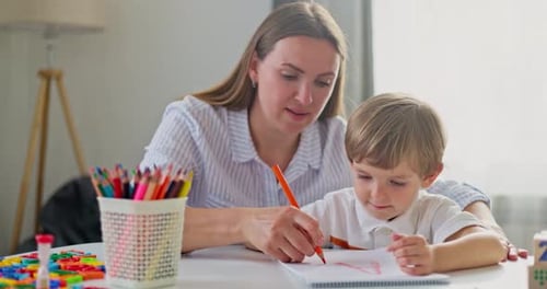 Woman and Child Drawing Together at a Table