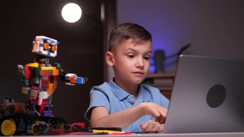 Robô de programação Focused Boy em laptop