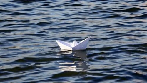 Paper Boat Floating on Rippling Water