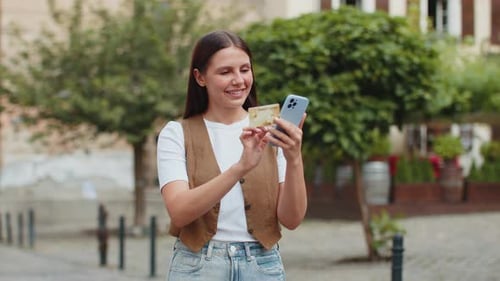 Happy Caucasian Woman Using Credit Card Smartphone While Purchases Online Shopping on City Street