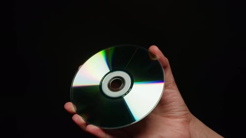 CD Disk in Hands on Black Background Closeup Old Vintage Disks for DVD Player or Computer Music
