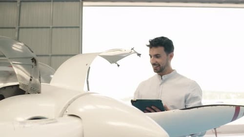 Aircraft Engineer Inspecting Plane with Digital Tablet in Slow Motion
