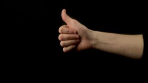 Hand Giving Thumbs Up Gesture on Black