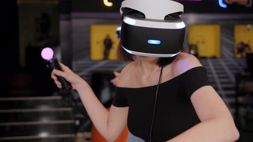 Primer plano de dos adolescentes jugando a videojuegos con un casco de realidad virtual