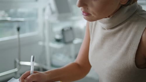 Woman Fills Out Form in Medical Office