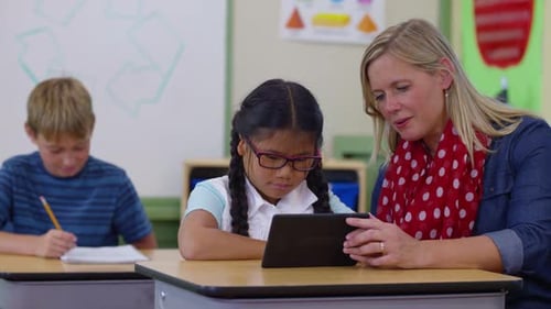 Teacher and Student Using Digital Tablet in School Classroom Asian