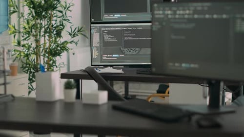 Escritorio vacío con varios monitores que muestran el código del servidor y el lenguaje de programación