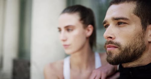 4k video footage of an affectionate young couple taking a break while out for a jog in the city
