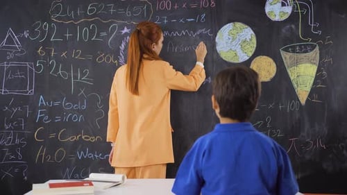 Teacher Explains Math to Student at Chalkboard