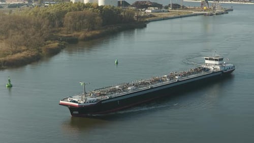 Crude oil tanker navigating the industrial port and its bustling waterways