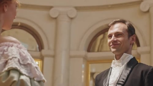 Elegantly Dressed Couple in Historical Hallway