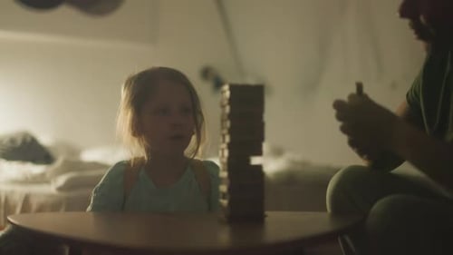 Die Dame startet das Jenga-Spiel, indem sie einen Holzblock vom Turm zieht