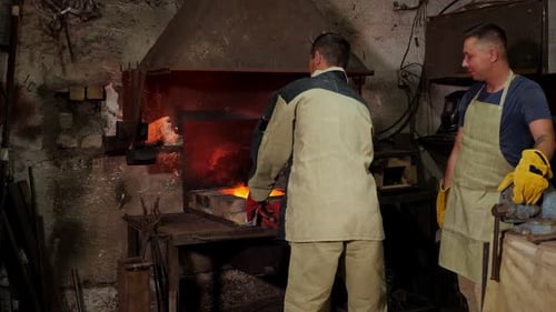 Men Working with Forge in Industrial Workshop