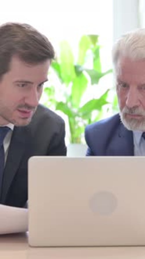 Two Men Working Together Looking at Laptop Screen