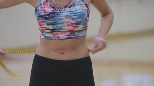 Une femme mesure la taille au gymnase pour perdre du poids