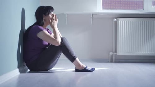 Depressed woman covering her face with her hand.
