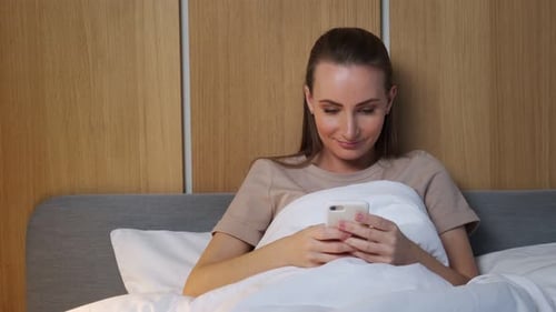 Woman Lying in Bed Using Mobile Phone
