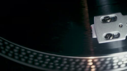 Der Musik-Vinyl-Plattenspieler mit rotierender Vinylplatte mit Musik auf einem schwarzen Plattenspieler. Ansicht von oben
