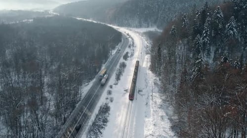 Aerial View of Train on Snowy Forest Railway in Winter