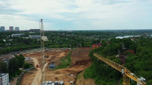 Grúa de torre alta y terreno vacío para construir en un suburbio
