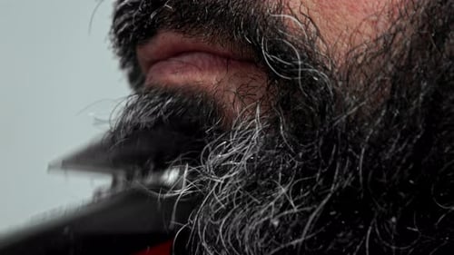 Man Trimming Black and Gray Beard with Clippers