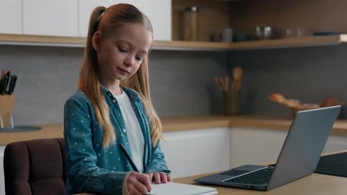 Caucasian Kid Girl School Pupil Elearning in Apartment Homeschooling Studying Online in Kitchen