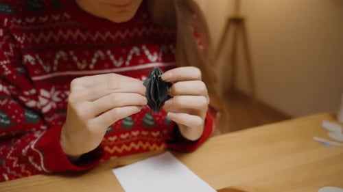 Young Woman Crafts a Christmas Ornament at Home