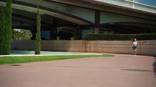 Woman Jogging in Urban Park on Sunny Day