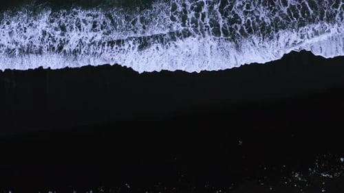 Black Sand Beach With Foamy White Waves of Atlantic Ocean. - aerial top down