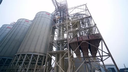 Modern industrial plant. Grain elevators on nature background