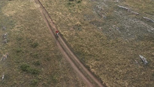 Extreme Pro Motocross Biker Riding on Back Wheel on Country Road in Wild Area