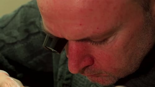 Man Repairing Watch with Magnifier and Tweezers