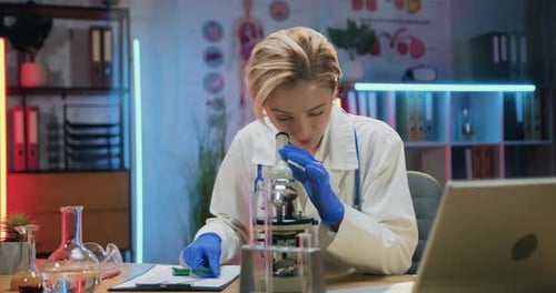 Woman Scientist Using Microscope in a Bright Lab
