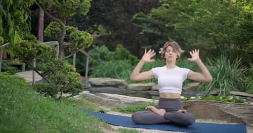 Woman Meditating Outdoors in a Beautiful Garden