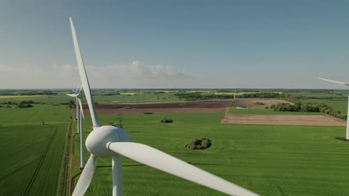 Close up of giant windmill turbine blades spinning in the air, drone