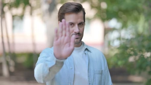 Outdoor Portrait of Young Man in Denial, Stop Gesture