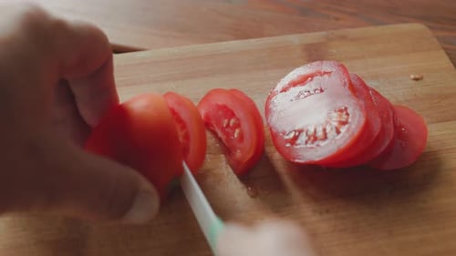 Slicing Fresh Red Tomato on Wooden Cutting Board