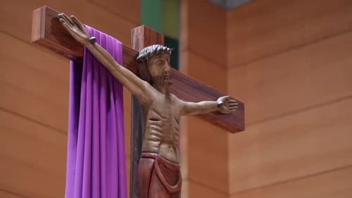 Jesus Christ crucifix statue with purple cloth in church
