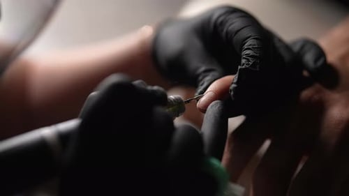 Manicurist Filing Finger Nail with Nail Drill