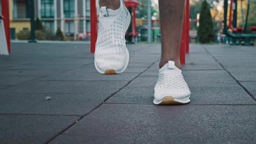 Close Up Legs of Male Athlete in White Trendy Sneakers Professional Sports Shoes Running on Spot