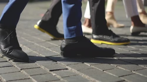 Beine von Geschäftsleuten, die die Straße entlang gehen