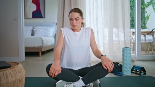 Woman Stretches Upper Body Sitting on Exercise Mat