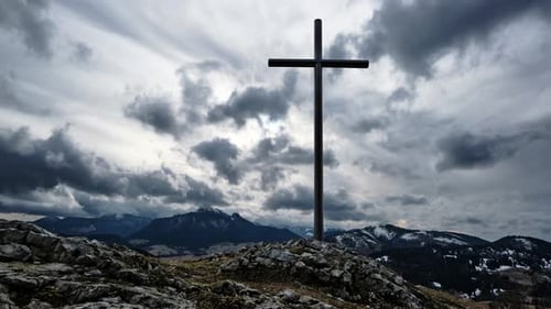 Christian Cross on a Rock in a Mountain Landscape Silhouette of the Mountains in Winter Timelapse