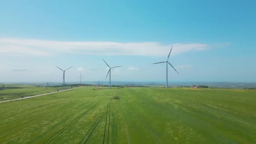 Wind Turbines Spinning in a Green Field