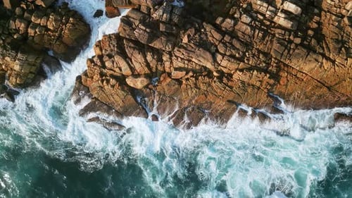 Drone of Azure Waves Meeting Rugged Tropical Coastline Aqua Ocean Swirls Crashes Into Jagged Rocks
