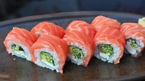 Philadelphia sushi rolls on a black plate at a restaurant