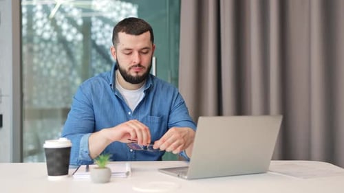 Man Working on Laptop in Modern Office