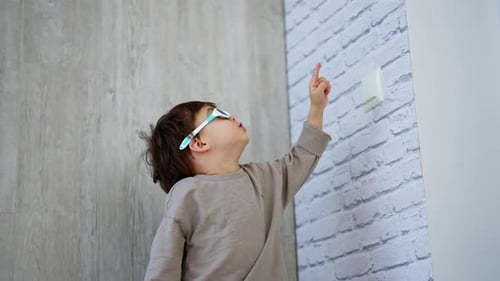 Young Child Pointing Upward by the Wall