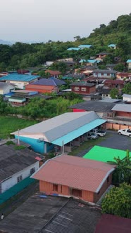 Rural Village in Thailand From Drone View with Small Houses Built Between the Trees and the Road