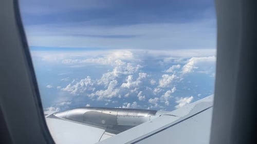 Aile d'avion survolant l'océan et l'île depuis la fenêtre sur les nuages dans un ciel bleu nuageux Aile d'avion
